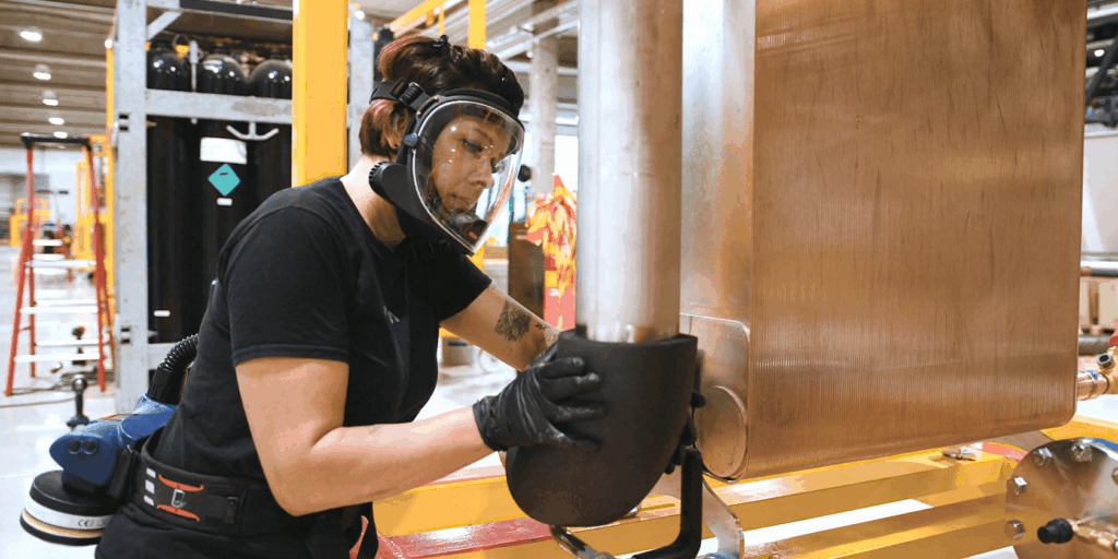 Eristäjänä työskentelevä Nina Ylianttila asettaa eristysmateriaalia putken ympärille.